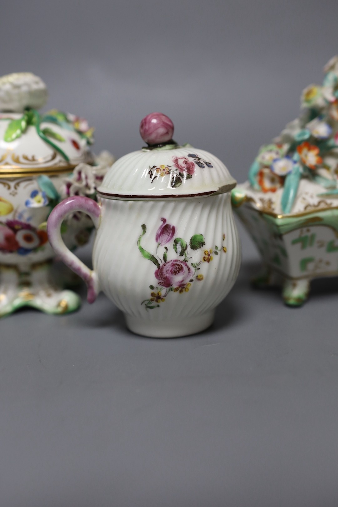 An 18th century Mennecy porcelain cup and cover, a Meissen style cup and cover, an English porcelain floral encrusted double inkwell and cover and a similar jar and cover